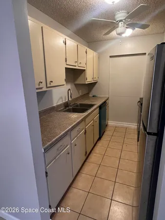 a kitchen with a sink a refrigerator a stove and cabinets