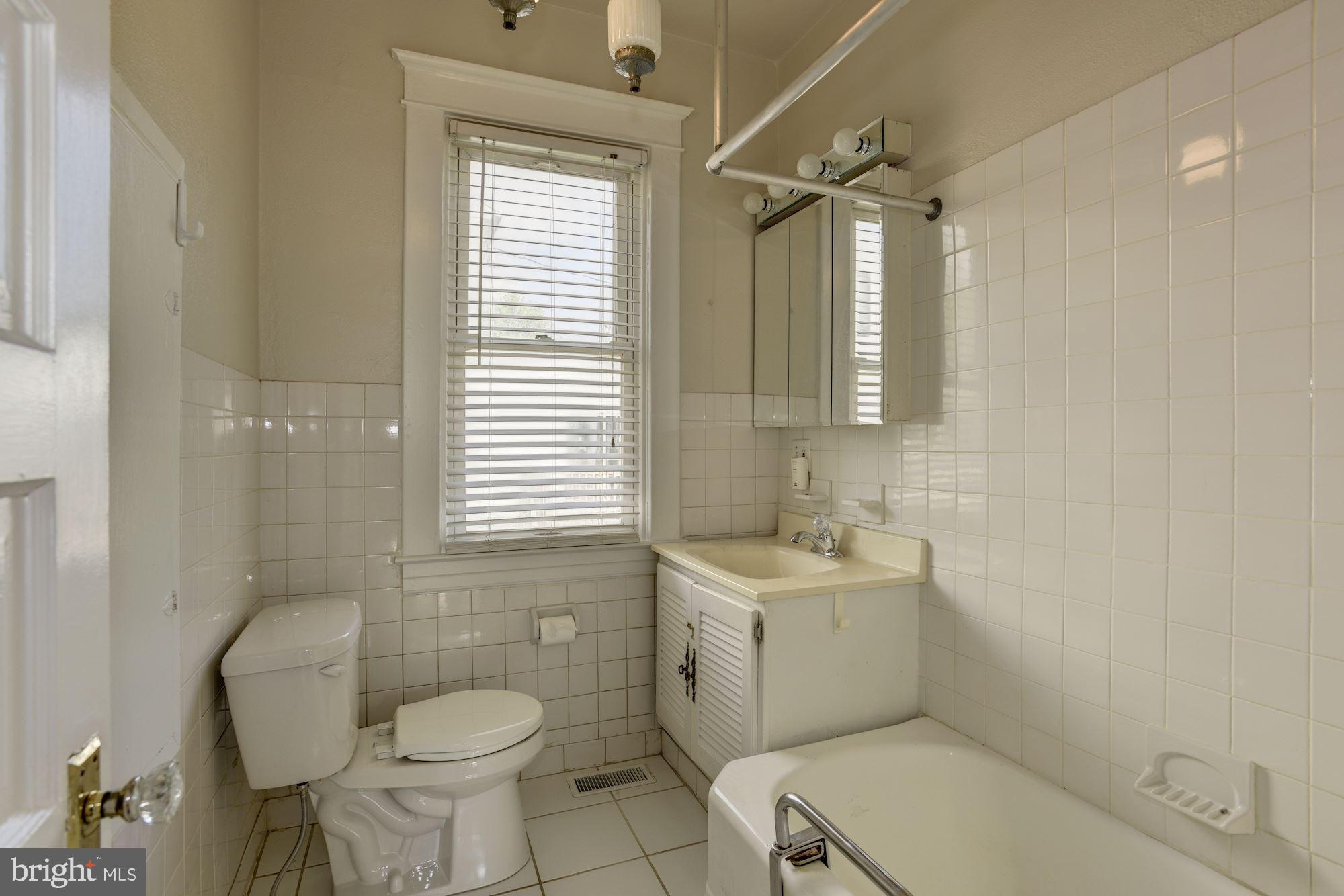 903 Arran Road Baltimore, MD 21239 - Photo 23 of 40 Tiled Hall bath with new toilet, sink fixtures.