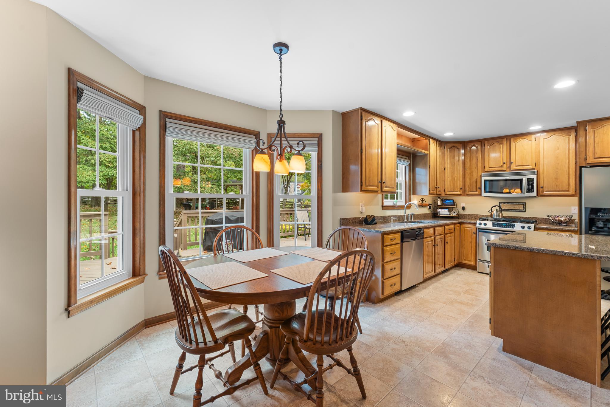 1433 Gilbert Road Arnold, MD 21012 - Photo 15 of 63 a kitchen with stainless steel appliances granite countertop a stove top oven a sink dishwasher a dining table and chairs with wooden floor
