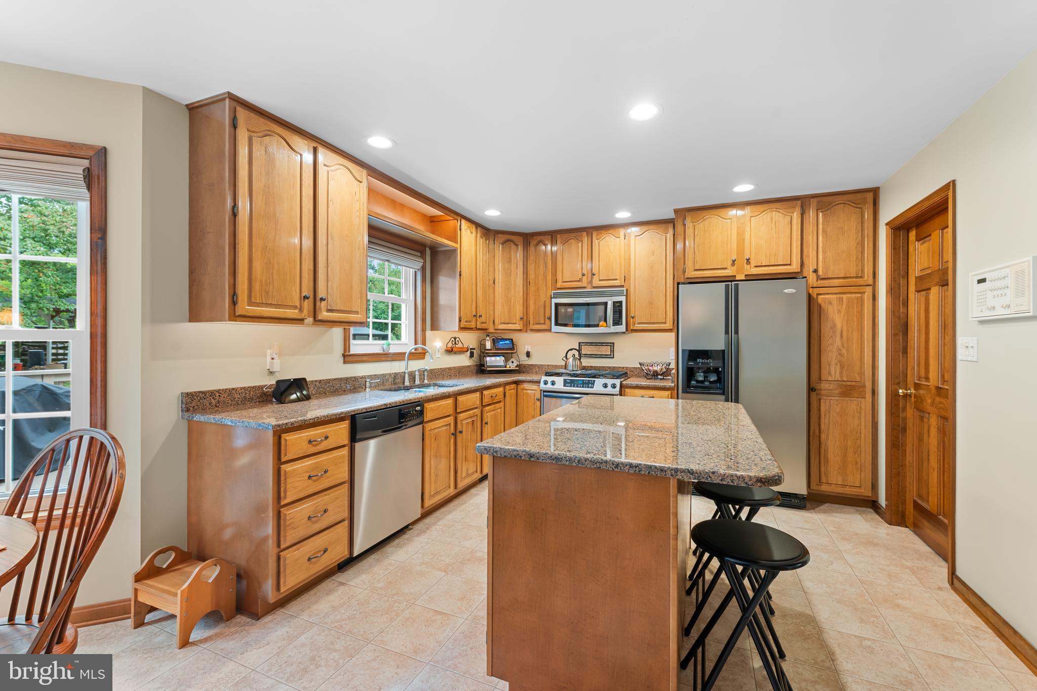 1433 Gilbert Road Arnold, MD 21012 - Photo 17 of 63 a kitchen with stainless steel appliances granite countertop a refrigerator a sink dishwasher a stove and a dining table with wooden cabinet