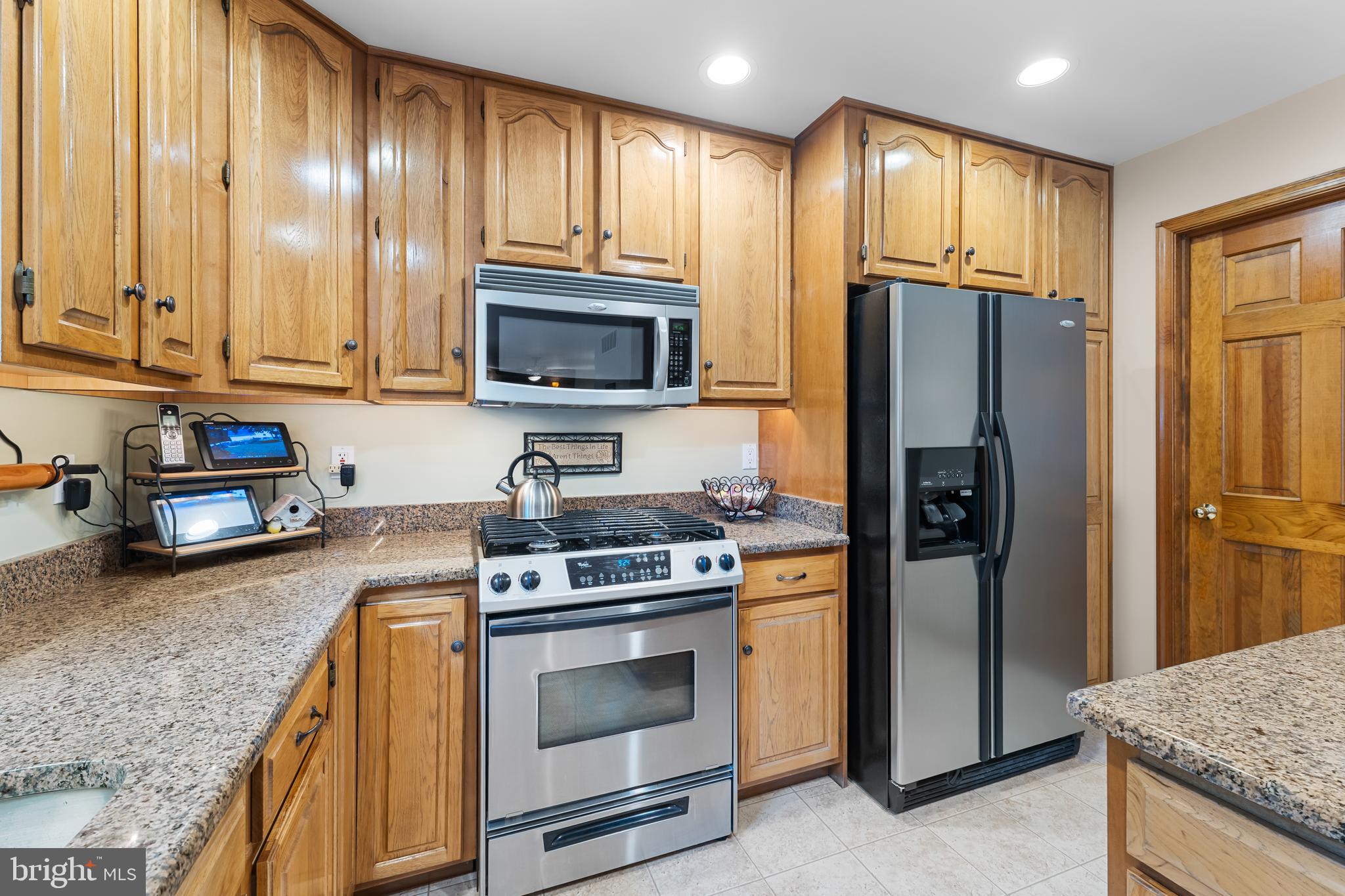 1433 Gilbert Road Arnold, MD 21012 - Photo 19 of 63 a kitchen with granite countertop wooden cabinets stainless steel appliances and a window