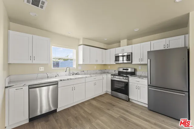 a kitchen with white cabinets and stainless steel appliances