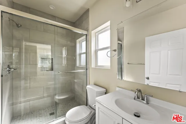 a bathroom with a sink a toilet and shower