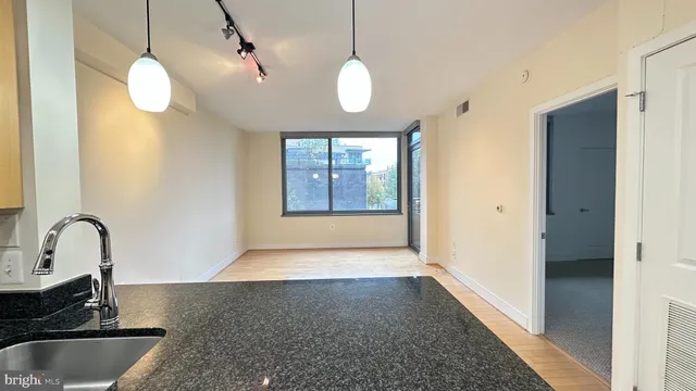 a kitchen with wooden floor window and mirror