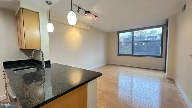 a kitchen with stainless steel appliances granite countertop a refrigerator a stove and a sink