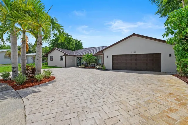 a front view of a house with a yard and potted plants