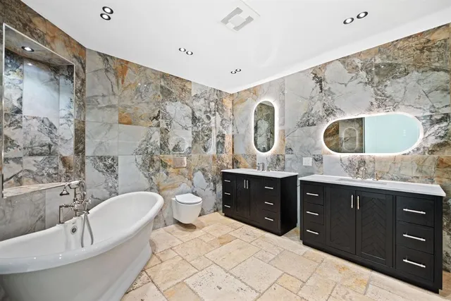 a spacious bathroom with a granite countertop sink mirror and bathtub