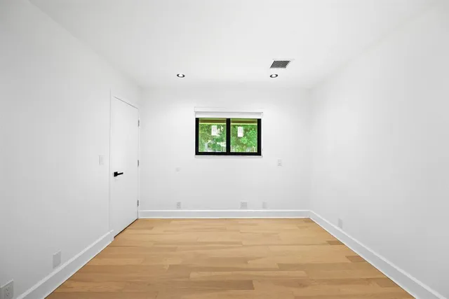 a view of an empty room with wooden floor