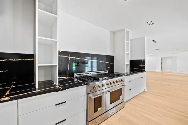 a kitchen with stainless steel appliances a stove and a microwave