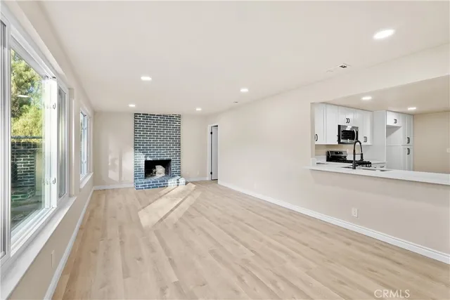 a view of an empty room with a fireplace and a window