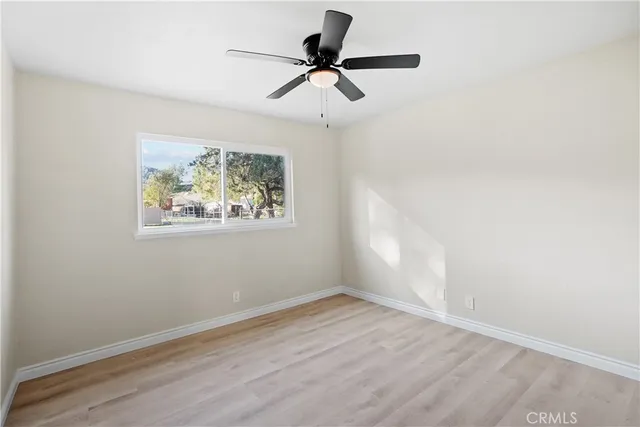 a view of an empty room and chandelier fan