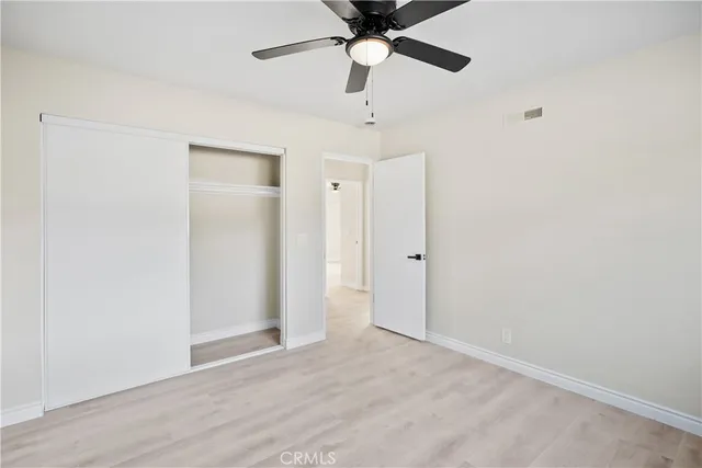 a view of a room with wooden floor closet and windows