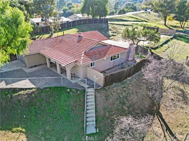an aerial view of a house with a yard and large trees