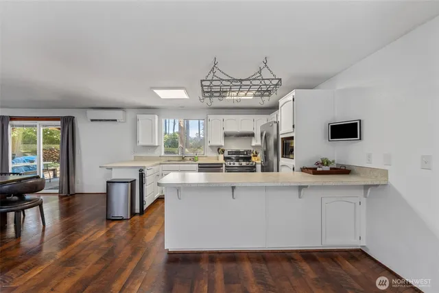 a kitchen with kitchen island granite countertop a sink cabinets and wooden floor