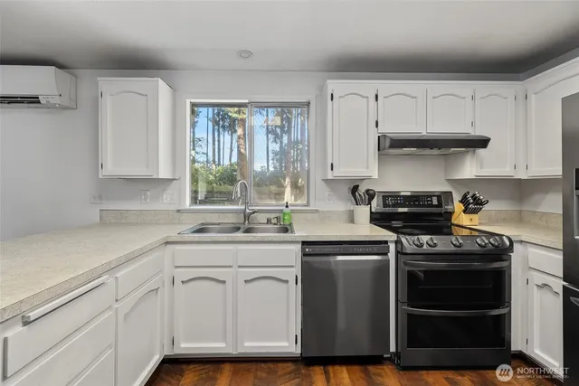 a kitchen with white cabinets and appliances