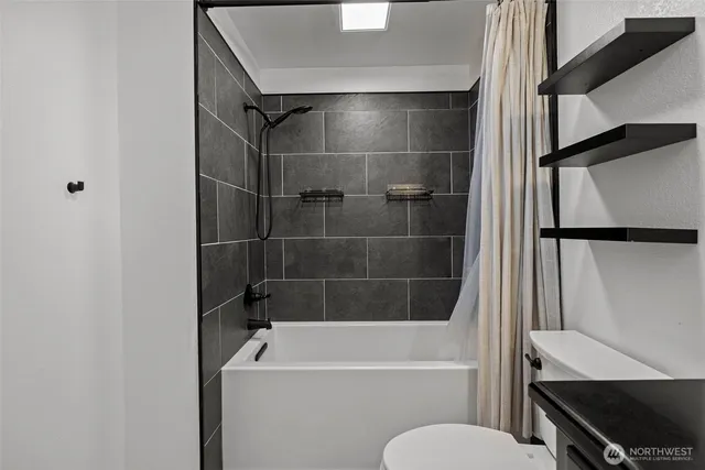 a bathroom with a tub a toilet and a sink