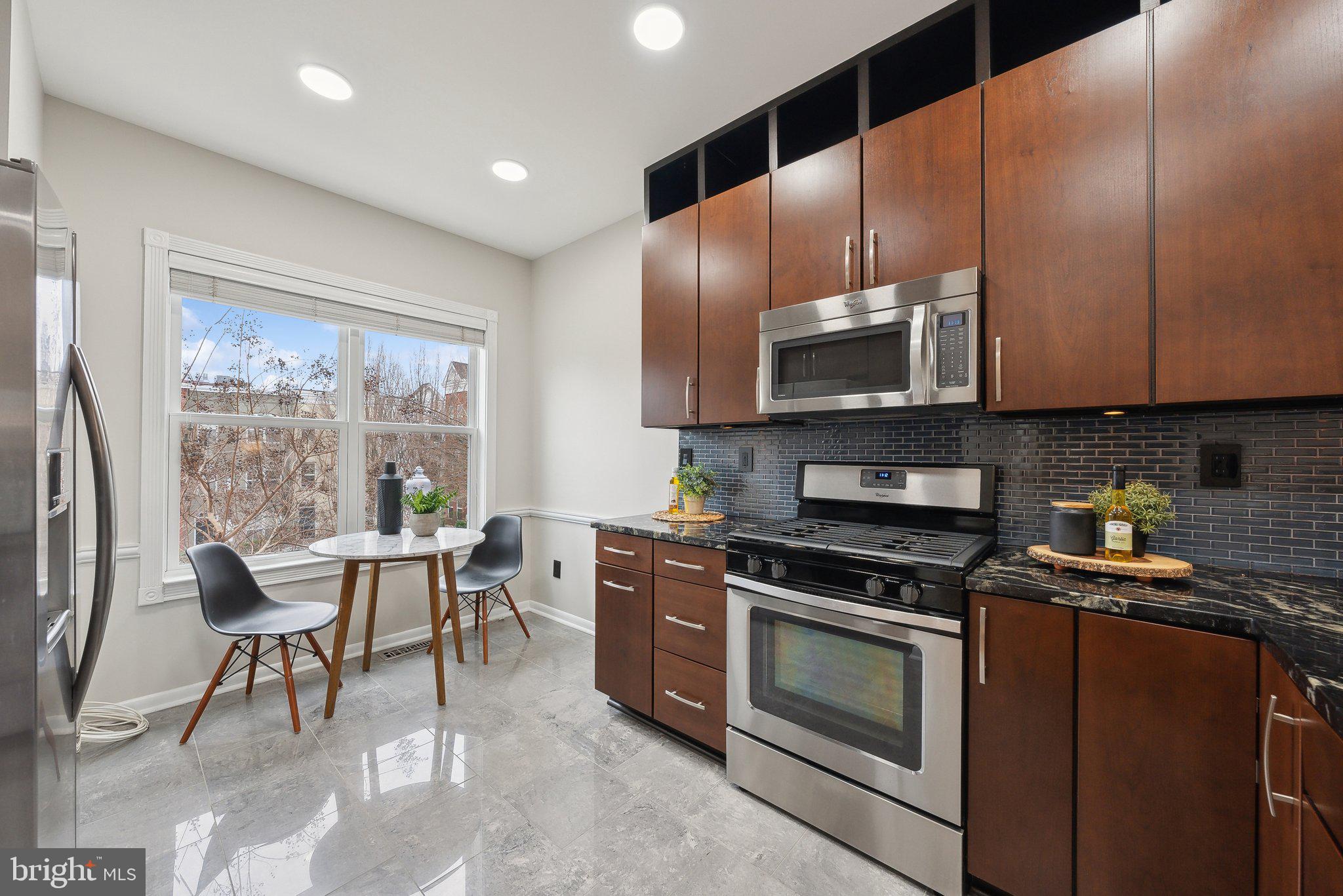 2136 12th Place Northwest Washington, DC 20009 - Photo 6 of 32 a kitchen with stainless steel appliances granite countertop a stove a sink and a microwave