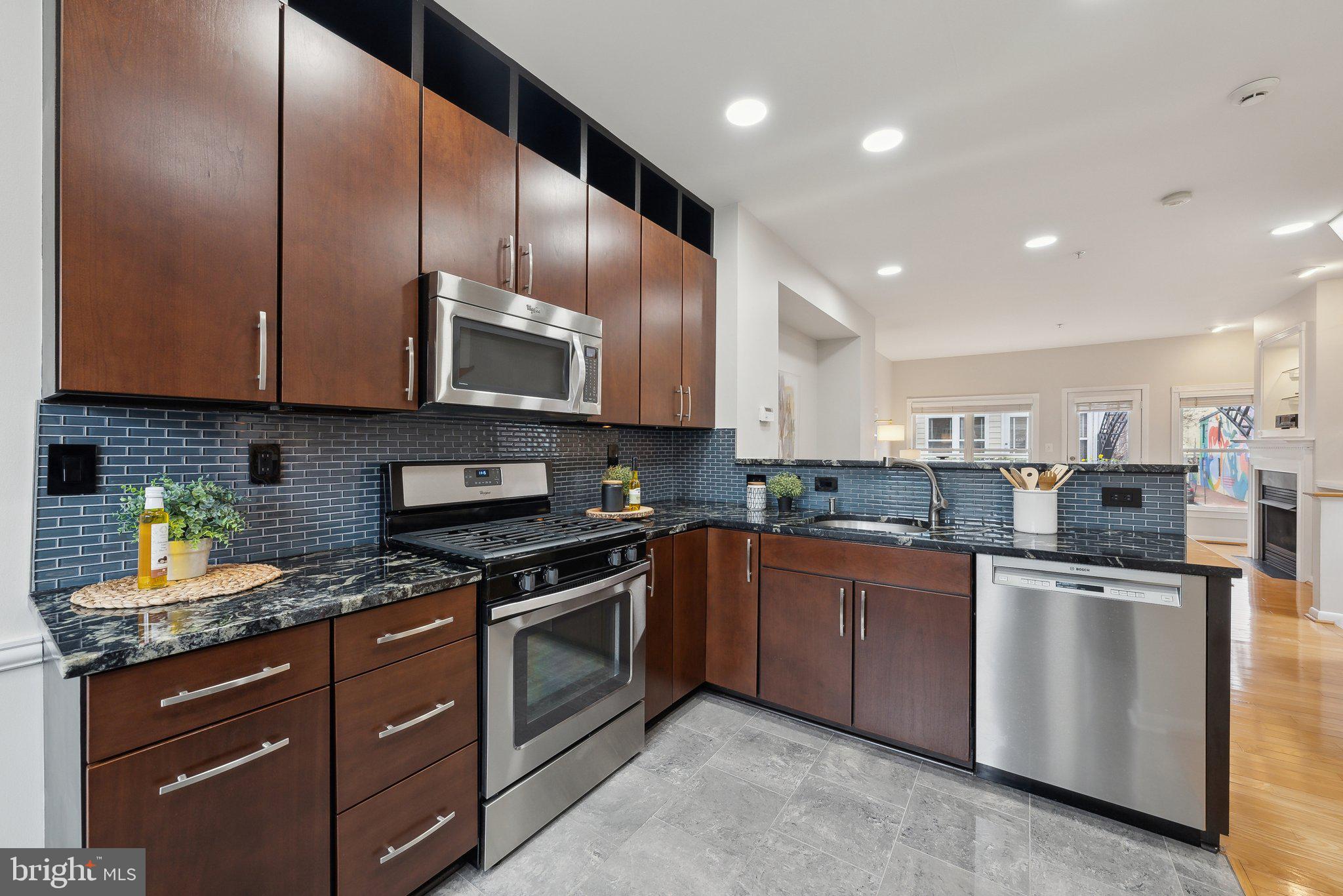 2136 12th Place Northwest Washington, DC 20009 - Photo 7 of 32 a kitchen with stainless steel appliances granite countertop wooden cabinets a stove a sink and a dishwasher