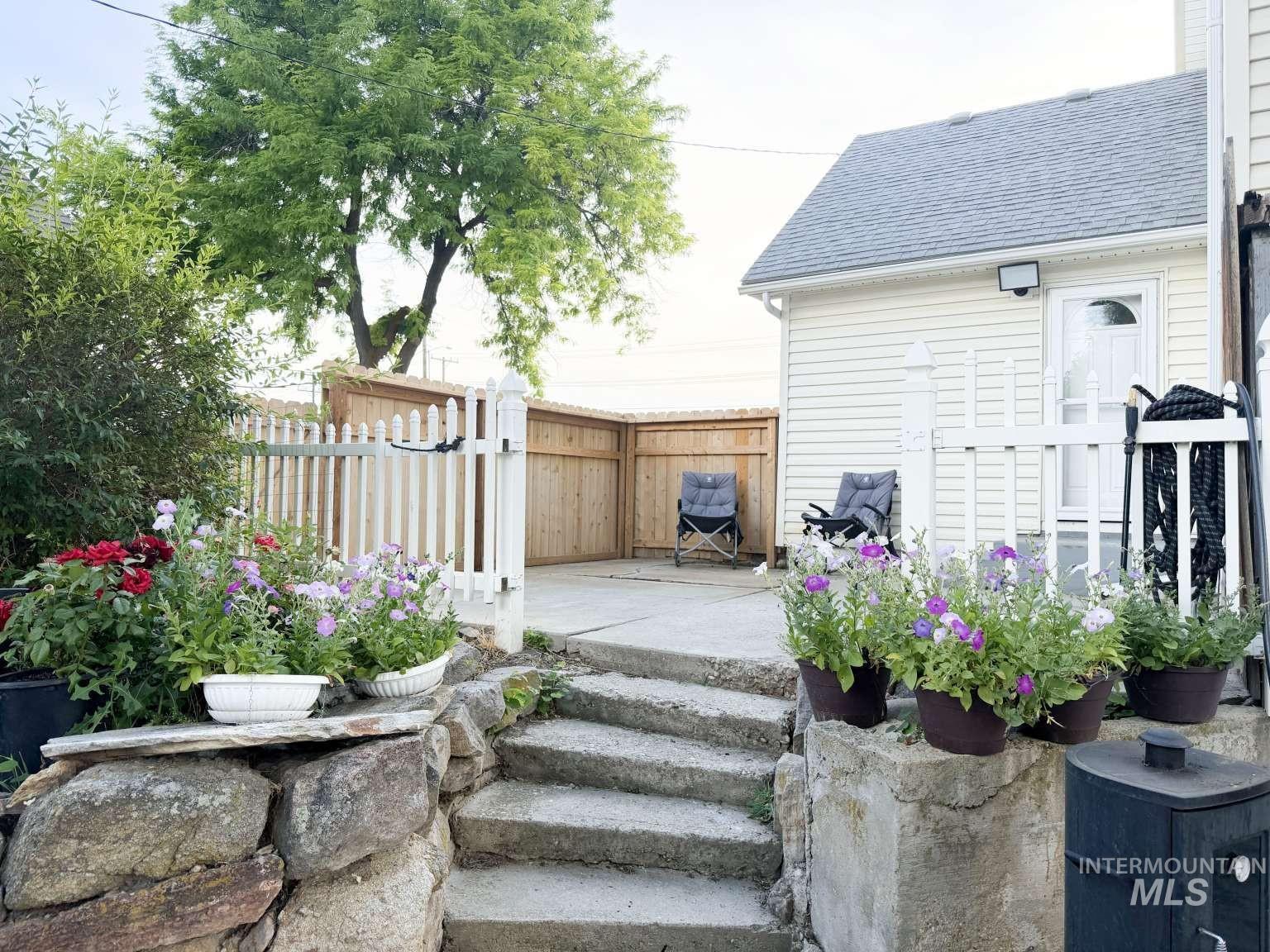 1158 South Powerline Road Nampa, ID 83686 - Photo 7 of 46 Concrete steps leading to a private patio area, surrounded by a combination wood and white picket fence
