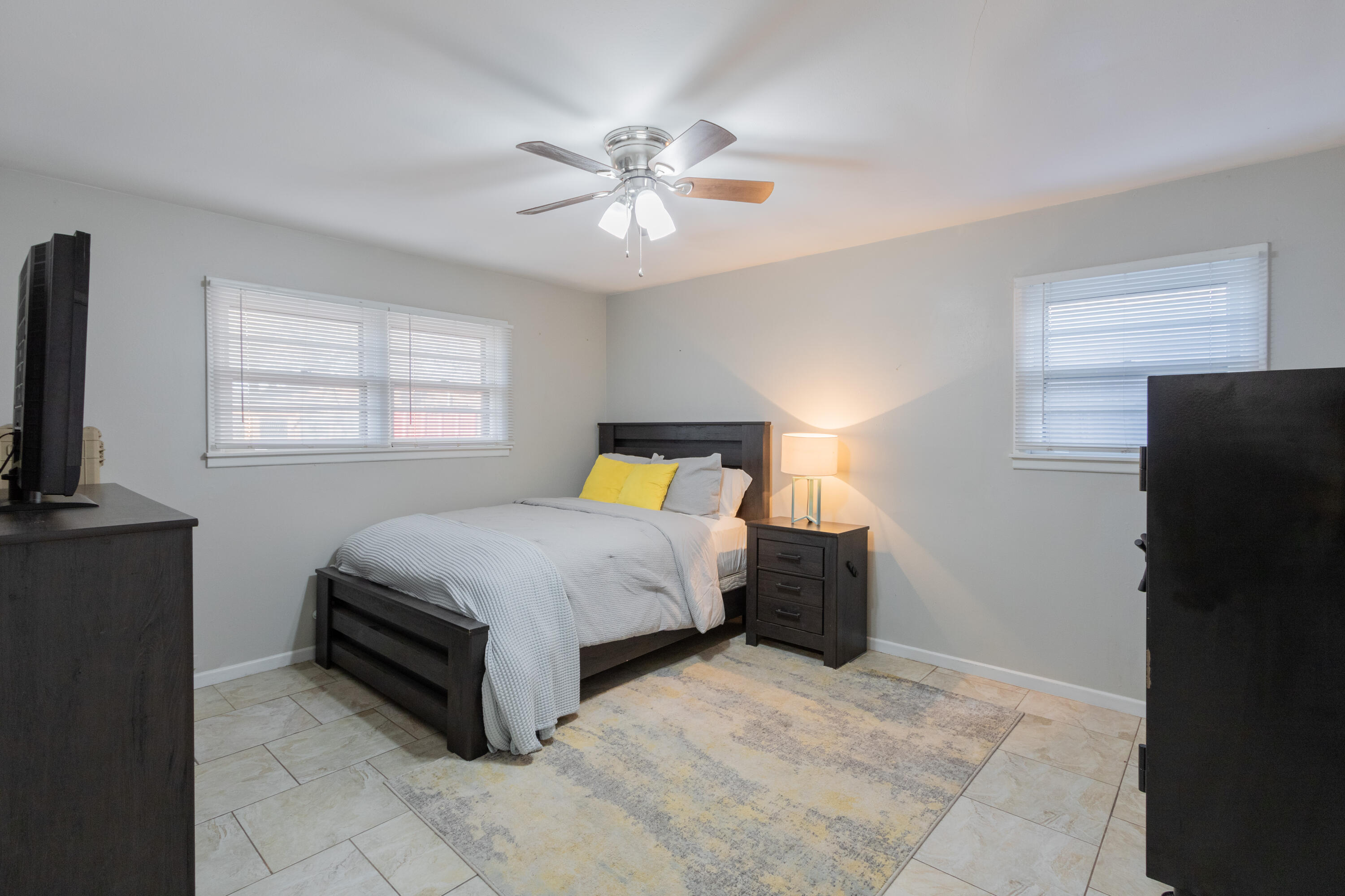 4404 49th Street Lubbock, TX 79414 - Photo 13 of 34 a bedroom with a bed and a chandelier