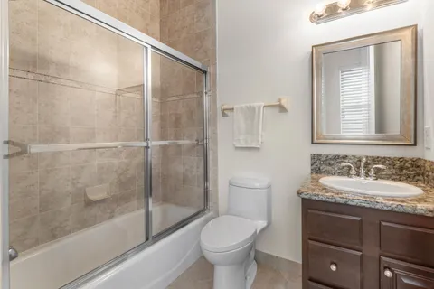 a bathroom with a granite countertop sink a large mirror and a shower