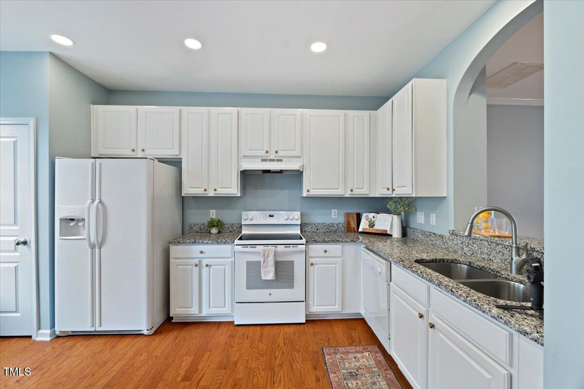 4533 Sugarbend Way Raleigh, NC 27606 - Photo 13 of 37 a kitchen with stainless steel appliances granite countertop a refrigerator sink and cabinets