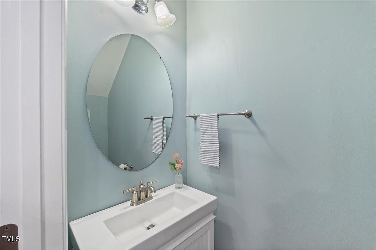 4533 Sugarbend Way Raleigh, NC 27606 - Photo 15 of 37 a bathroom with a sink and mirror