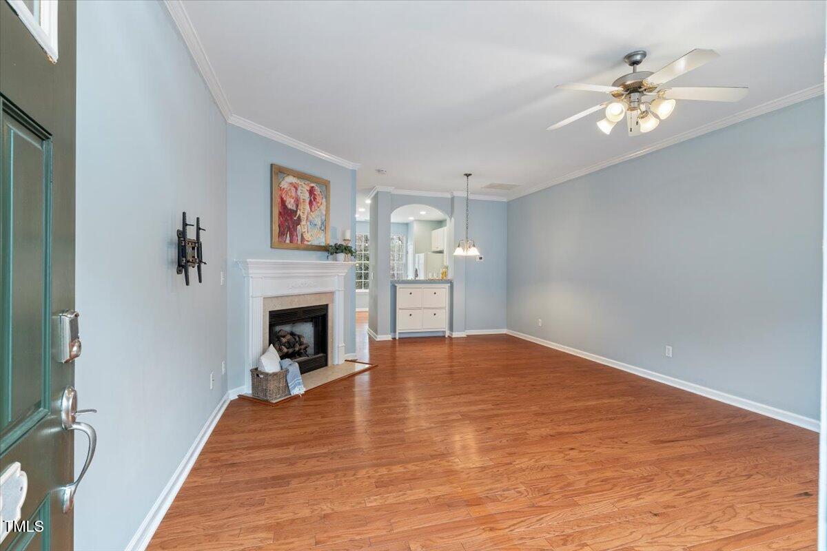 4533 Sugarbend Way Raleigh, NC 27606 - Photo 4 of 37 a view of a livingroom with a fireplace a chandelier and wooden floor