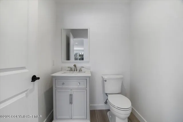 a kitchen with stainless steel appliances granite countertop a stove top oven a sink dishwasher a refrigerator and a dining table with wooden floor