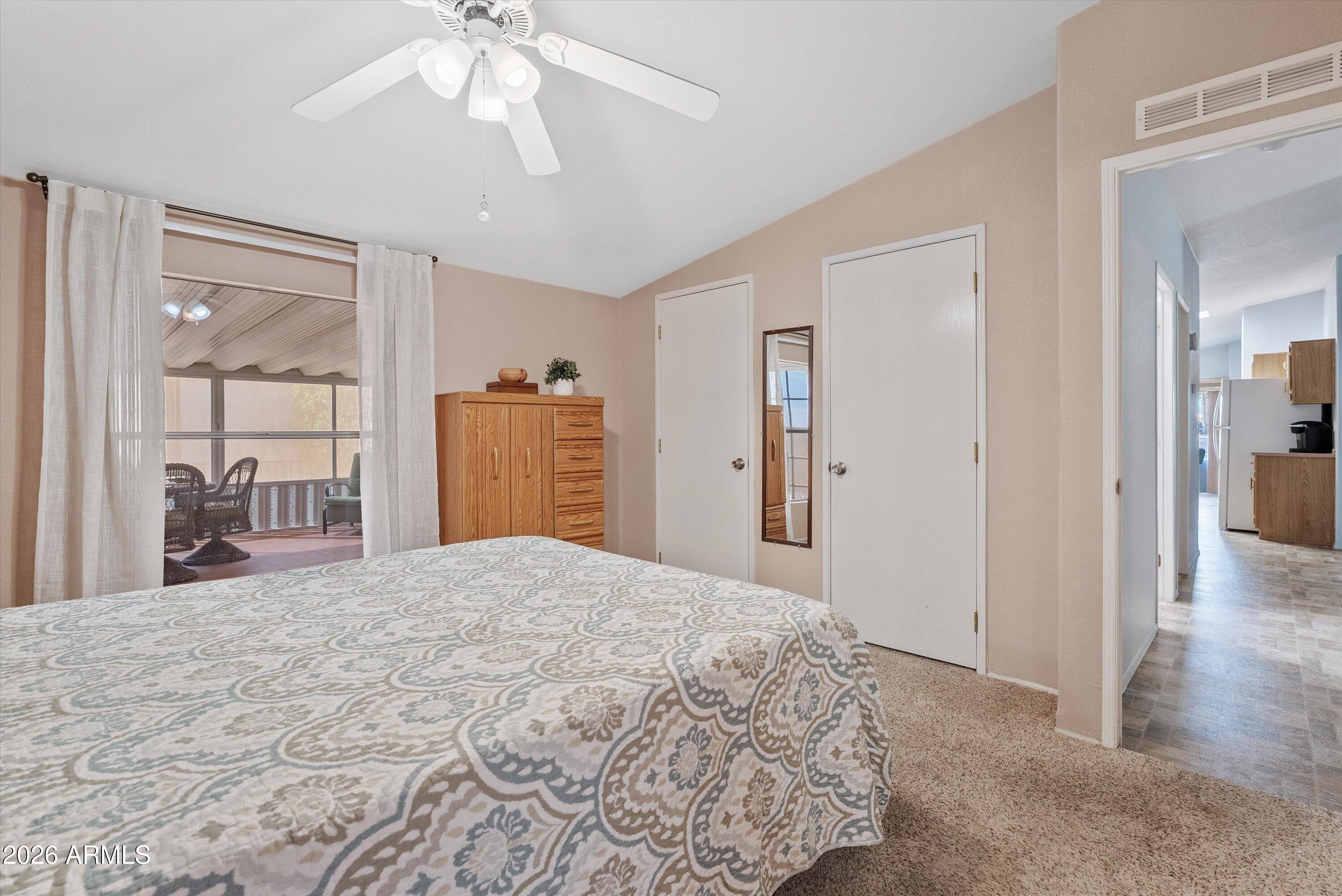 3700 South Tomahawk Road, Unit 91 Apache Junction, AZ 85119 - Photo 15 of 29 a bedroom with a large bed a chandelier and a mirror
