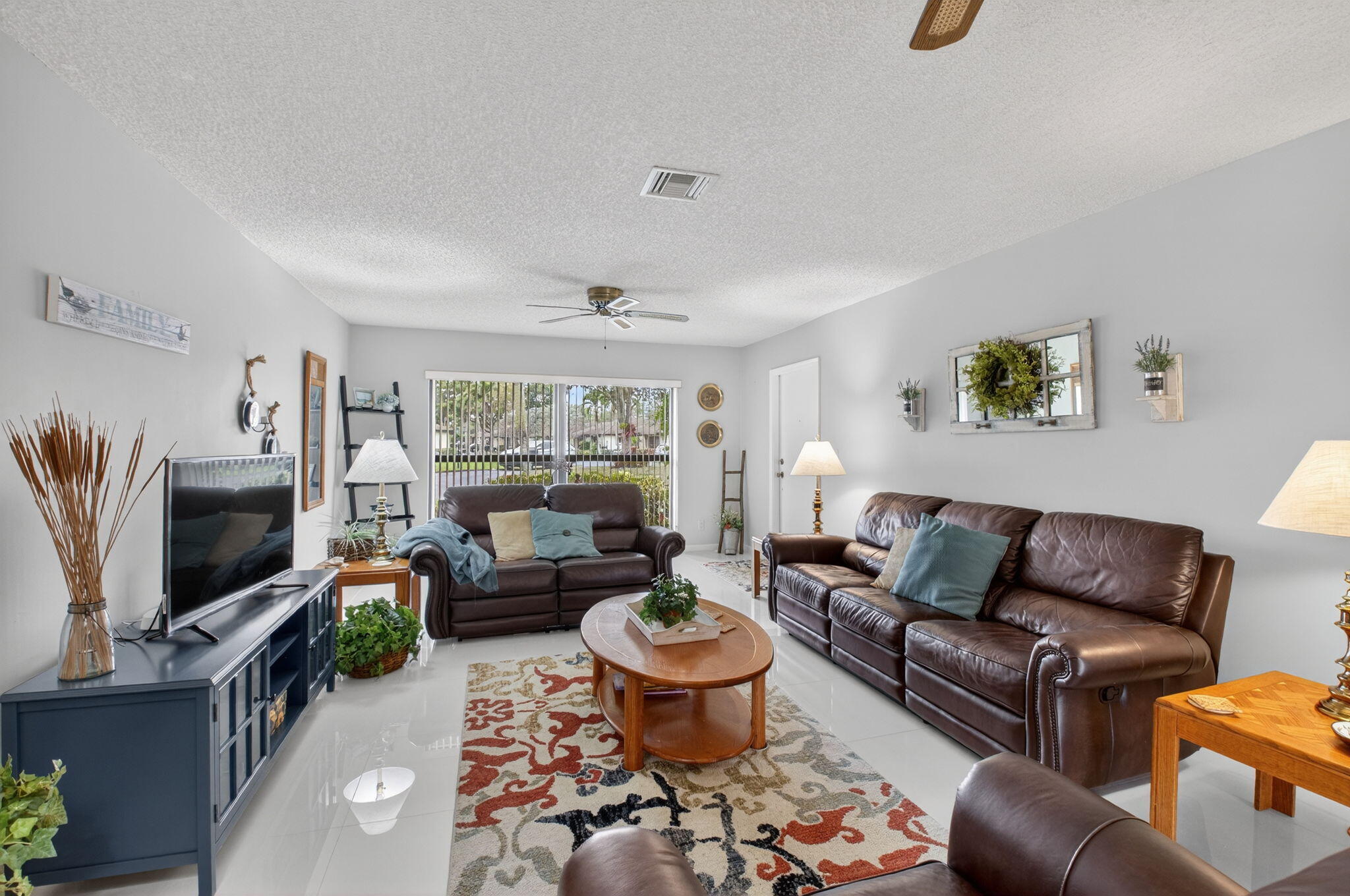 4972 Dovewood Road, Unit B Boynton Beach, FL 33436 - Photo 11 of 47 a living room with furniture a flat screen tv and a window