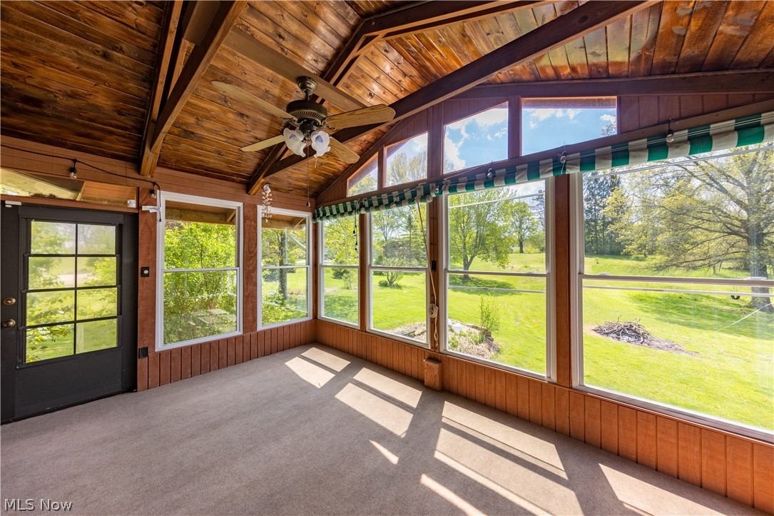 7969 Dines Road Novelty, OH 44072 - Photo 18 of 48 Enclosed sunroom featuring a wood-panel vaulted ceiling, expansive window walls, and carpet flooring