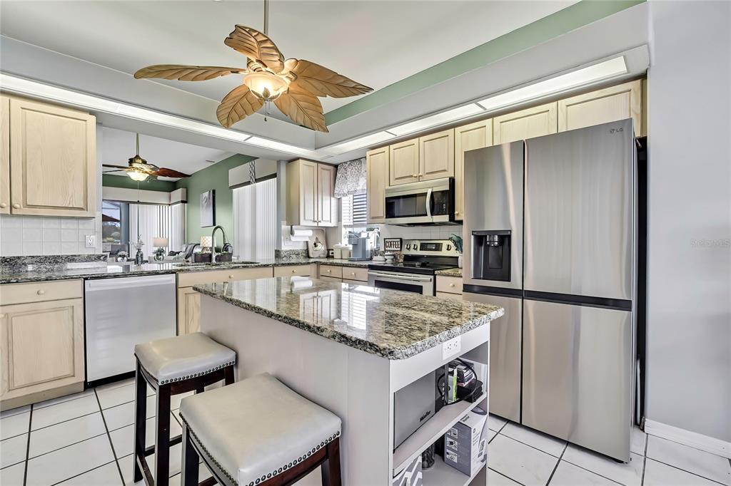 8472 Maybelle Drive Weeki Wachee, FL 34613 - Photo 20 of 58 a kitchen with kitchen island a counter top space appliances and cabinets
