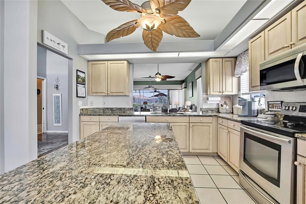 8472 Maybelle Drive Weeki Wachee, FL 34613 - Photo 22 of 58 a kitchen with stainless steel appliances granite countertop a stove sink and cabinets