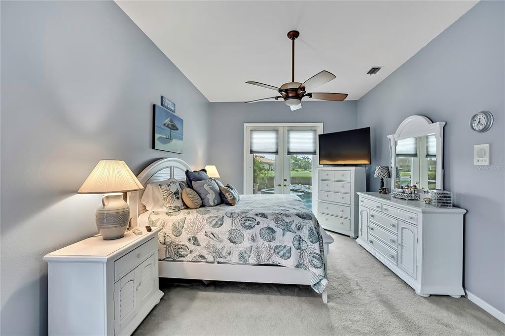 8472 Maybelle Drive Weeki Wachee, FL 34613 - Photo 25 of 58 a bedroom with a large bed and a flat tv screen on dresser