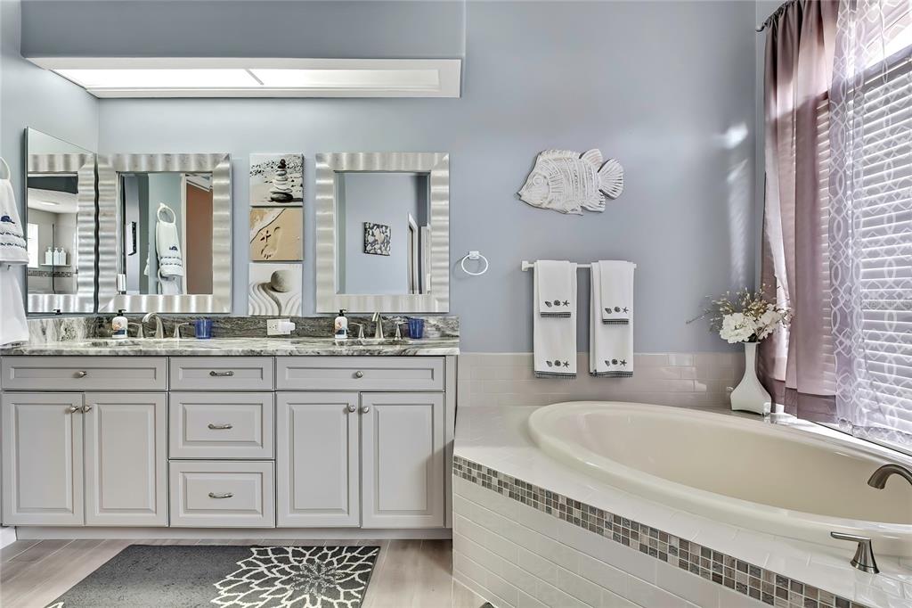 8472 Maybelle Drive Weeki Wachee, FL 34613 - Photo 27 of 58 a bathroom with a granite countertop tub sink and mirror