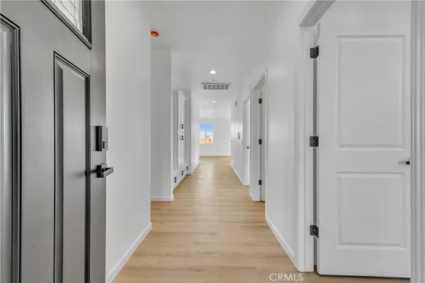 a view of a hallway with wooden floor and a glass door