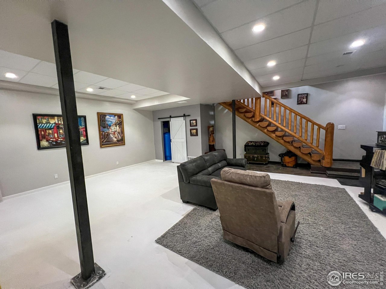 27667 Buckhorn Road Bellvue, CO 80512 - Photo 15 of 40 a living room with couches and a dining table with wooden floor