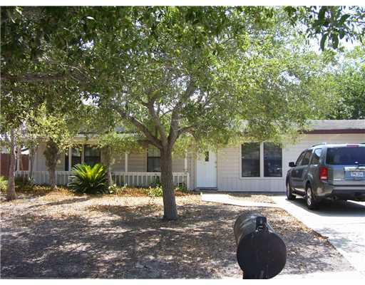 a view of a house with a large tree in front of it