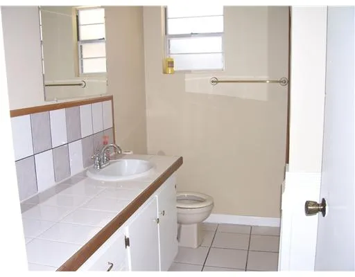 a bathroom with a sink a toilet and window