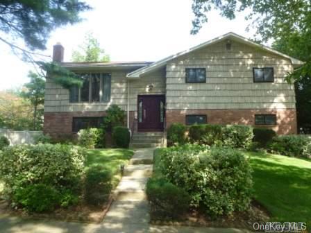 43 Cambridge Road Great Neck, NY 11023 - Photo 1 of 1 a front view of a house with a yard and potted plants