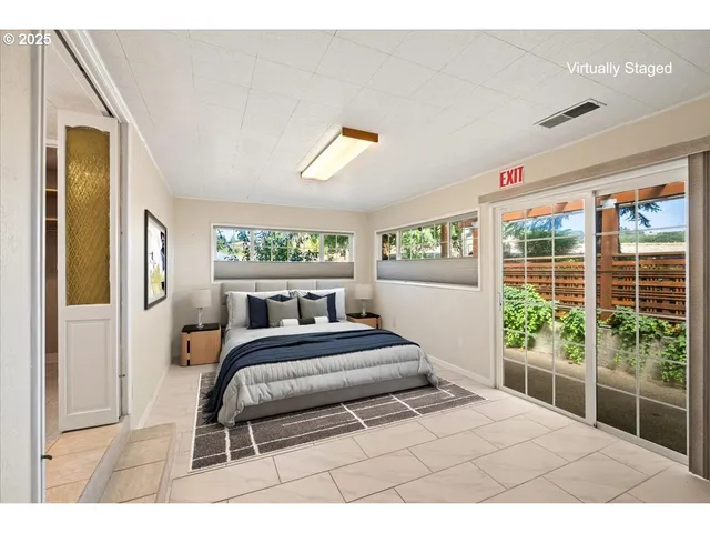 a bedroom with a bed and a large window