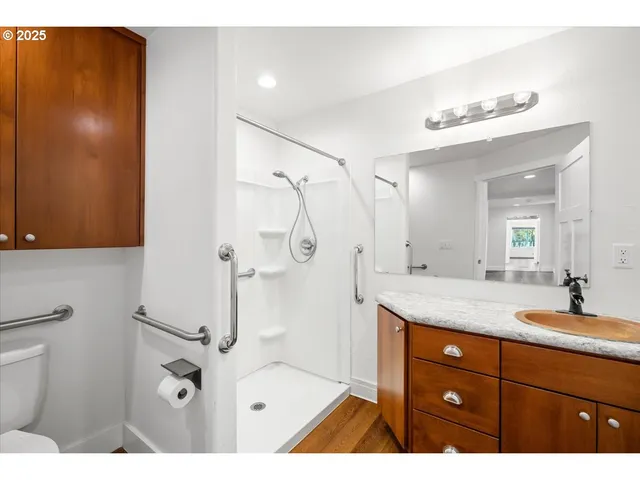 a bathroom with a granite countertop sink mirror and a shower