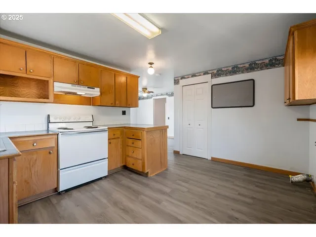a view of kitchen with wooden floor and electronic appliances