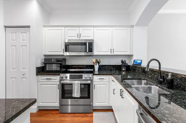 a kitchen with stainless steel appliances a sink stove and cabinets