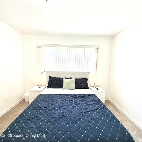 a view of a bedroom with a bed and a window