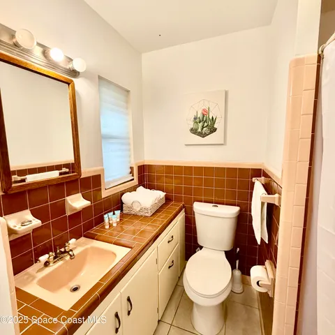 a bathroom with a granite countertop toilet sink and mirror