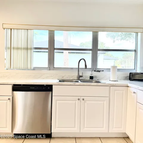 a kitchen with a window sink and cabinets