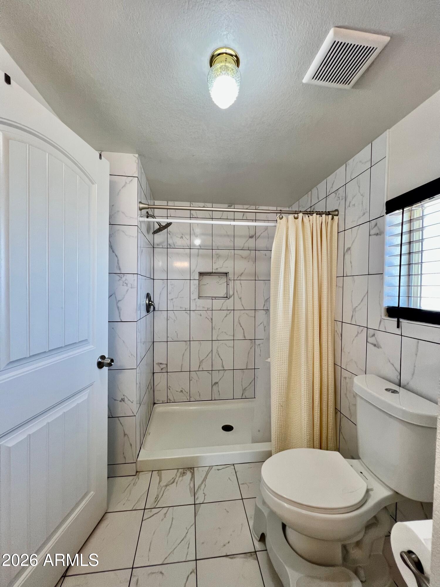 12035 East Tennyson Road Florence, AZ 85132 - Photo 5 of 42 a bathroom with a toilet and a shower
