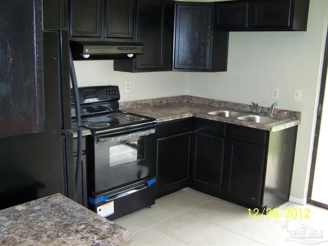 a kitchen with granite countertop a stove and a microwave